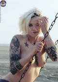 tattooed blonde gets naked at the beach